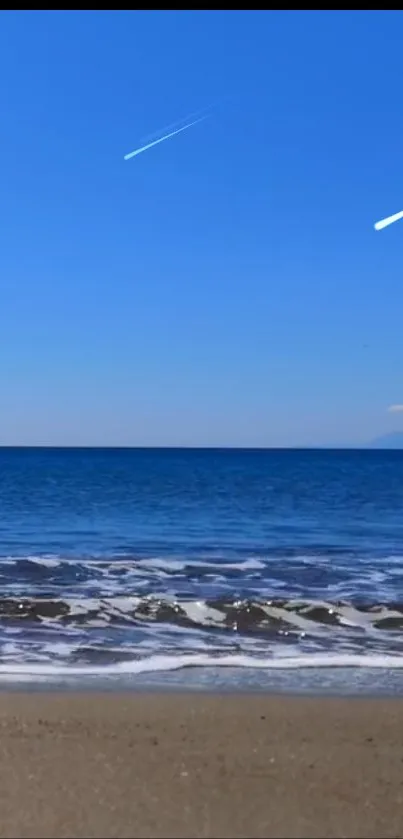 Mobile wallpaper of a serene beach with a clear blue sky.