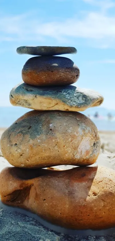 Serene stack of stones by the beach with a blue sky backdrop.