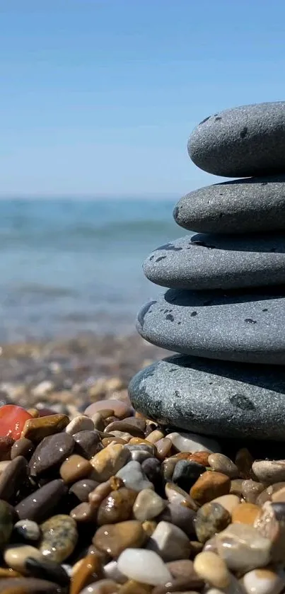 Stack of stones on a pebble beach with blue ocean background.