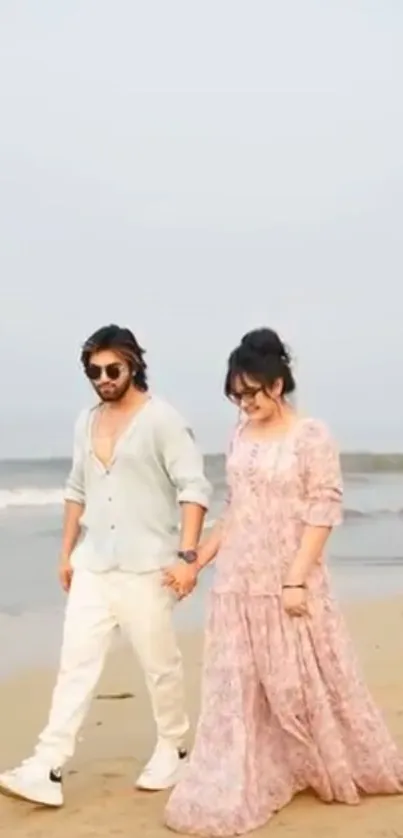 Couple walking on a serene beach together, holding hands.