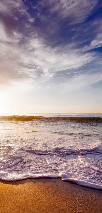 Serene sunrise over ocean and sandy beach.