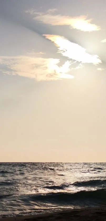 Serene beach sunset with gentle waves and a radiant sky.