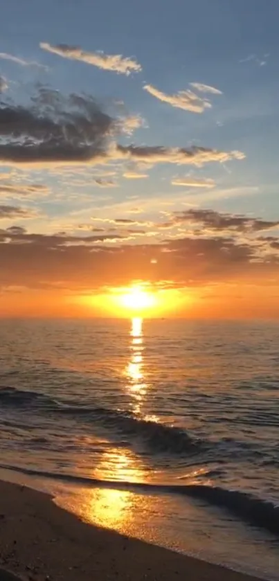 Orange sunset over a tranquil ocean with a clear sky.