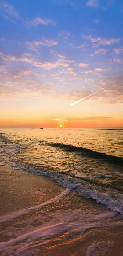 Serene beach sunset with waves and colorful sky.