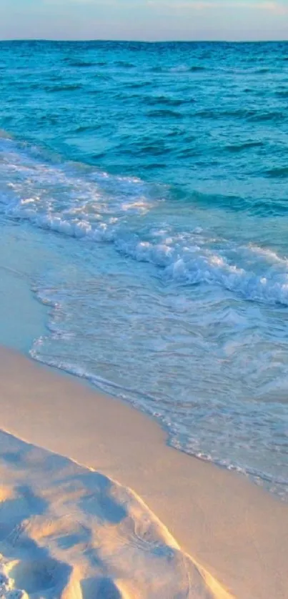 Serene beach sunset with ocean waves and sandy shore.