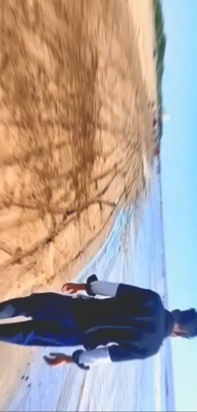 Person walking on a tranquil beach with the ocean and sky view.