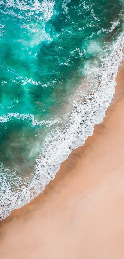 Aerial view of turquoise ocean waves meeting sandy beach.