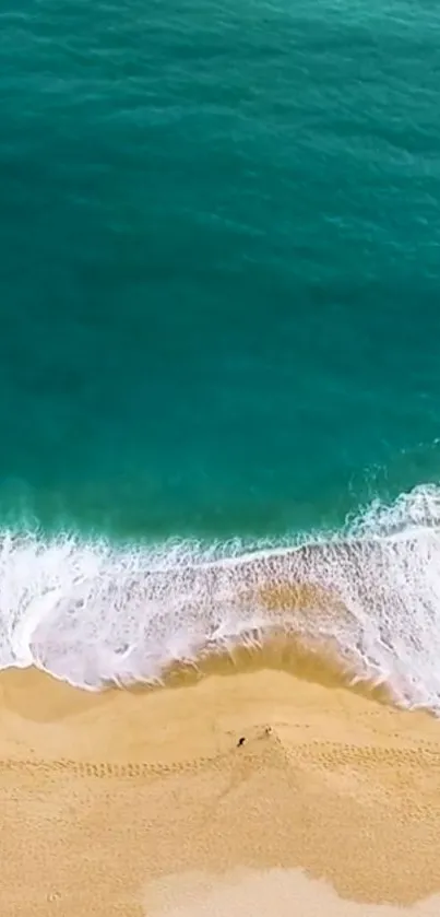 Aerial view of turquoise ocean waves meeting golden sand on a serene beach.