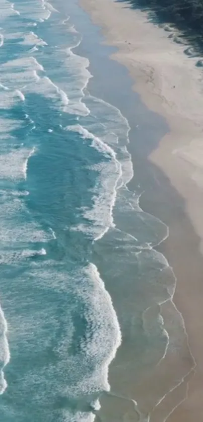 Aerial view of ocean waves softly hitting a tranquil sandy beach.