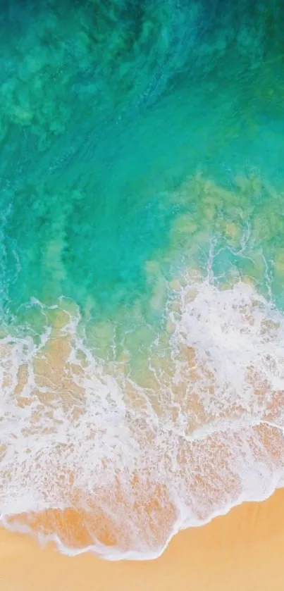 Aerial view of turquoise ocean waves meeting sandy beach shore.