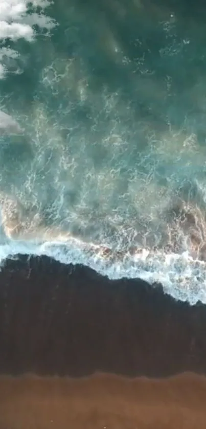 Aerial view of beach with teal waves crashing on shore.