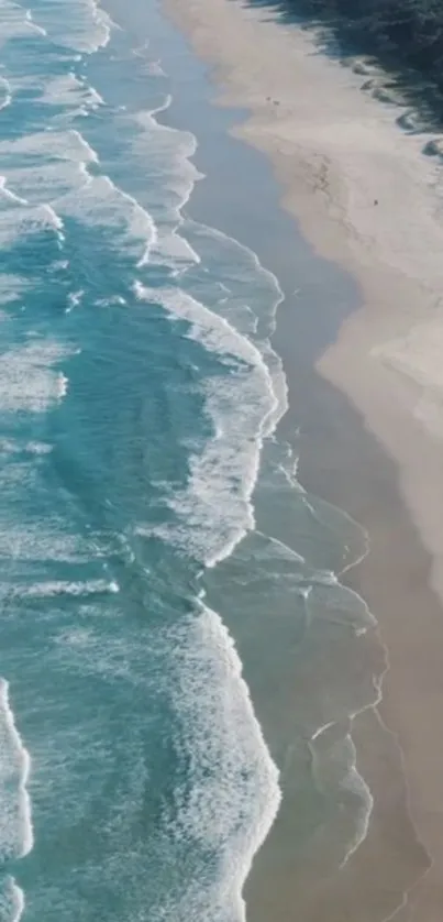 Aerial view of serene ocean waves on a sandy beach.