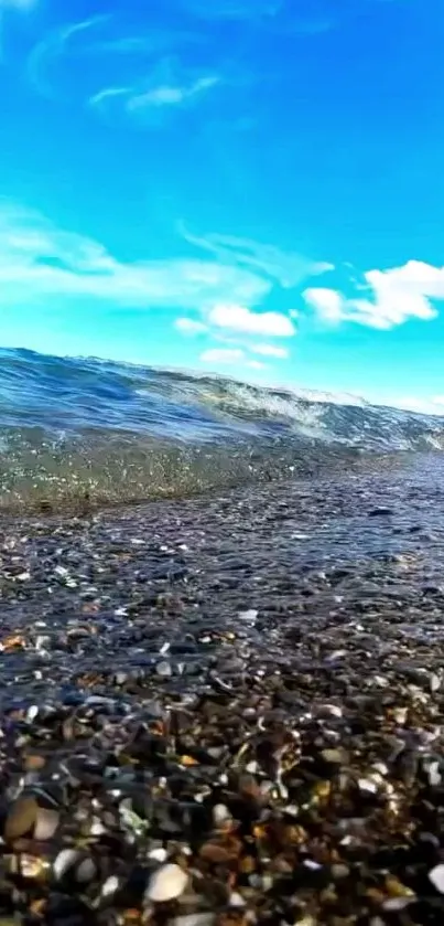 Serene beach with waves under a bright blue sky.