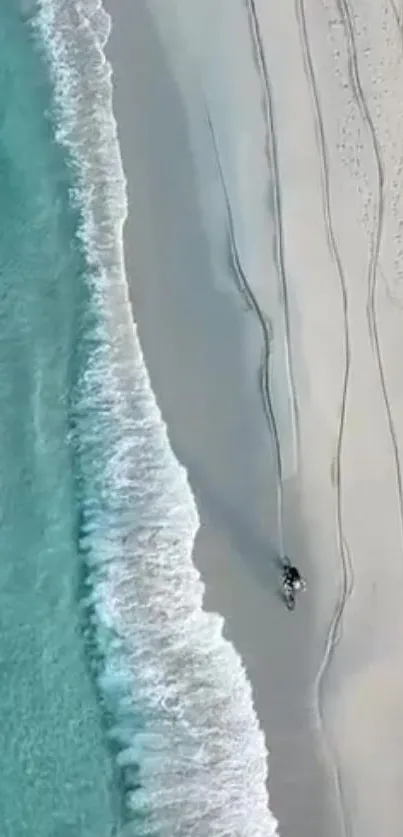 Aerial view of azure waves meeting sandy beach on a serene coastline.