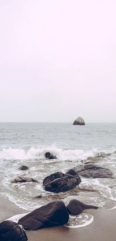 Tranquil beach scene with ocean waves and pale pink sky.