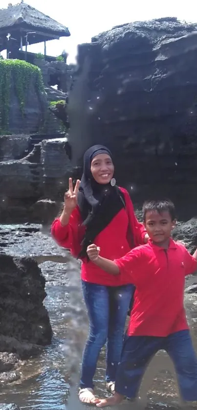 Mother and child at scenic rocky beach.