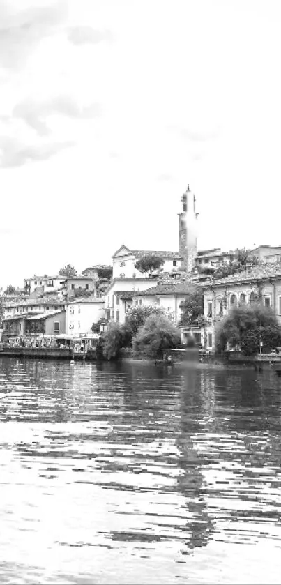 Black and white lakeside townscape with calm water reflections.