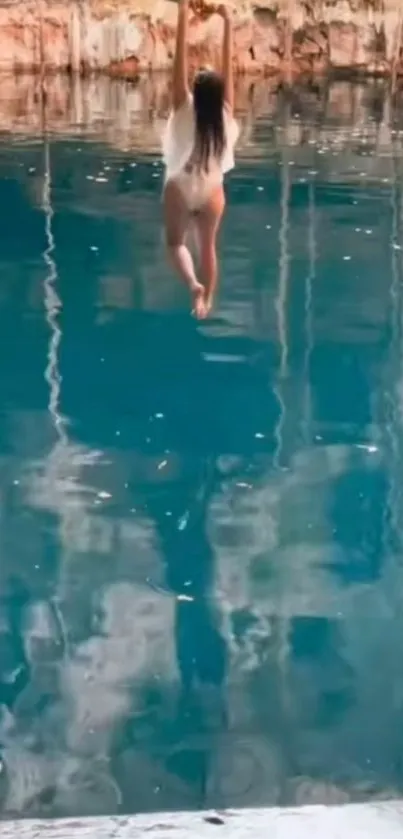 Person relaxing in hammock above serene teal cave pool.