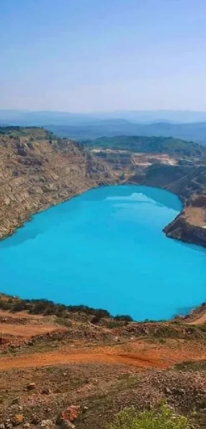 Bright blue lake surrounded by cliffs under a clear sky.