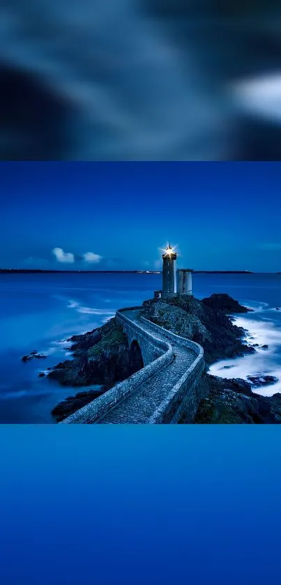 Lighthouse path at night with blue ocean and sky.