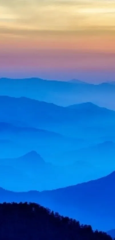 Serene blue mountains under a colorful sunrise sky wallpaper.