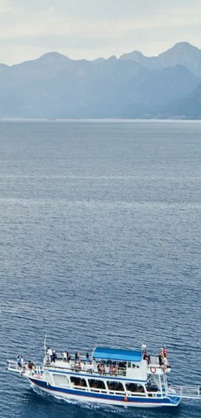 A boat sails on a vast ocean, framed by distant mountains.