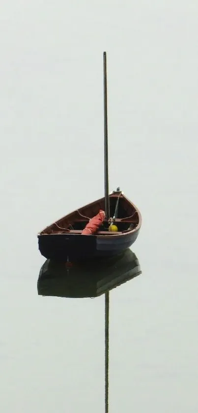 A solitary wooden boat reflected on calm, light gray water.