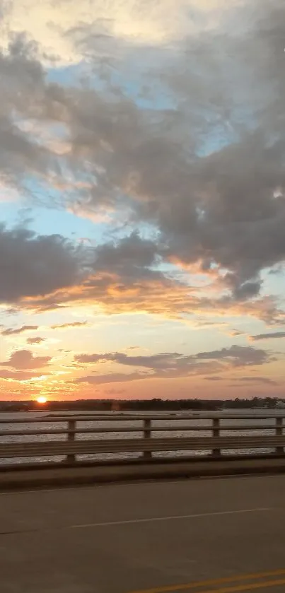 Serene sunset view over bridge with tranquil sky and clouds.