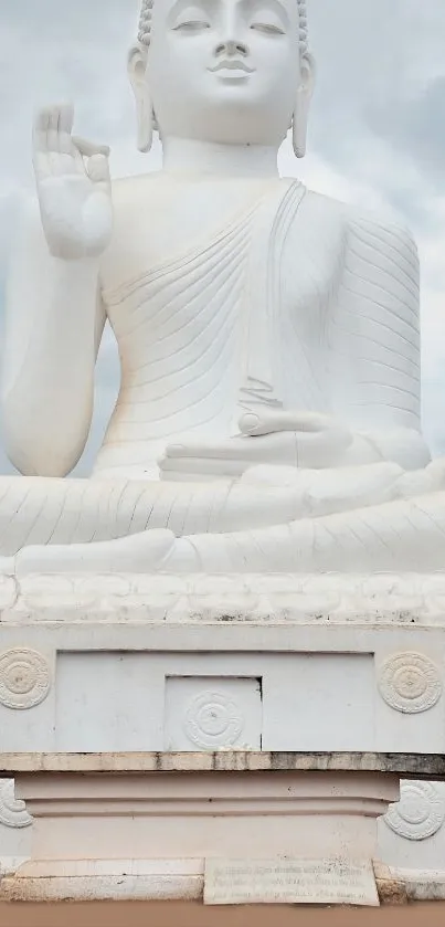 Buddha statue with serene expression against cloudy sky.