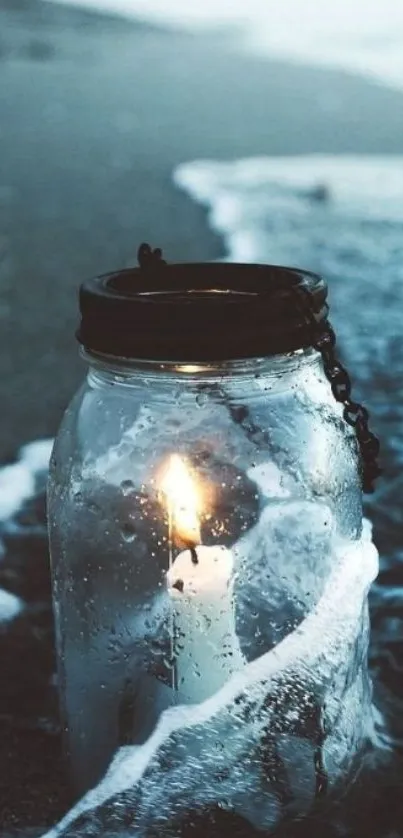 Candle in a jar on a serene ocean beach wallpaper.