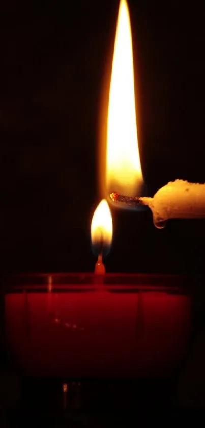 Warm candle flame emitting a soft, serene glow on a dark background.