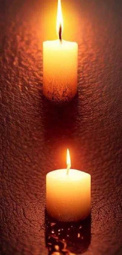 Two candles casting a warm glow against a dark brown background.