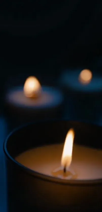 Candle light glowing in dark setting, perfect for phone wallpaper.