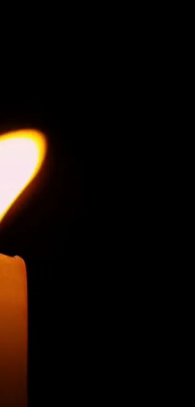 A glowing candle flame against a dark background.