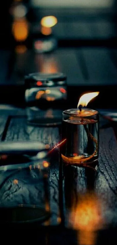 Candle in glass jar on wooden table emitting a warm glow.