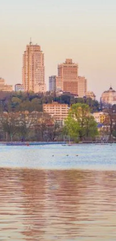 Tranquil cityscape at sunset with water reflections and pastel sky.