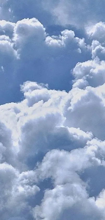 Fluffy clouds against a serene blue sky wallpaper.