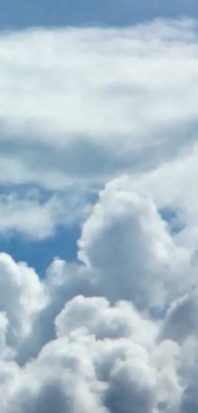 Fluffy white clouds in a clear blue sky wallpaper.