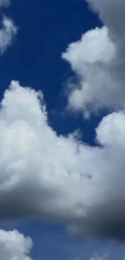 White fluffy clouds against a deep blue sky background.