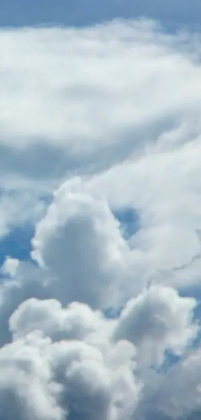 Serene blue sky with fluffy white clouds wallpaper.