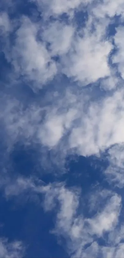 Fluffy white clouds against a blue sky, perfect for a serene phone wallpaper.