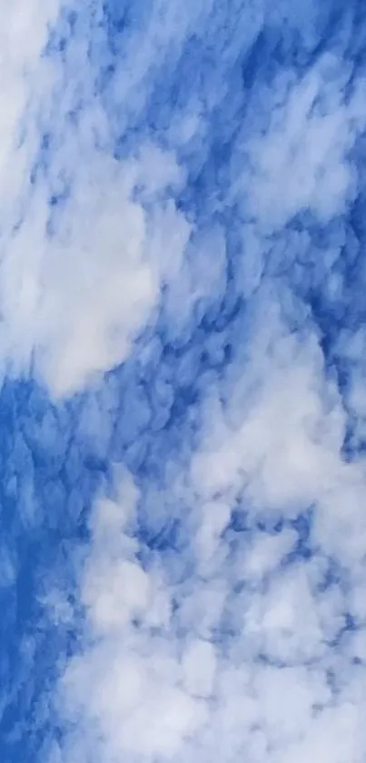 Blue sky with fluffy white clouds wallpaper.