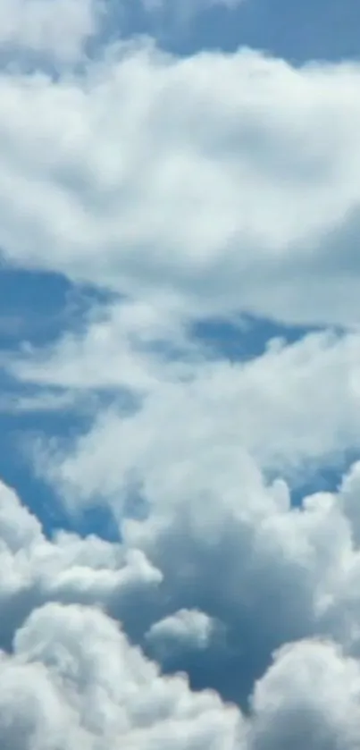 Serene blue sky with fluffy white clouds.