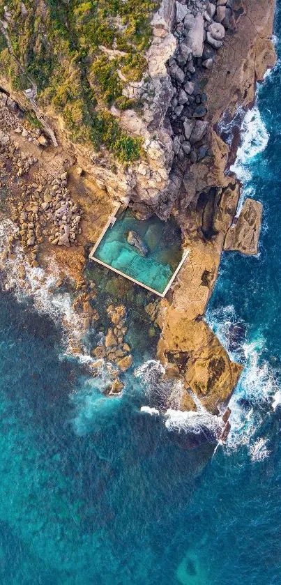 Aerial view of a rock pool by the turquoise ocean coast.