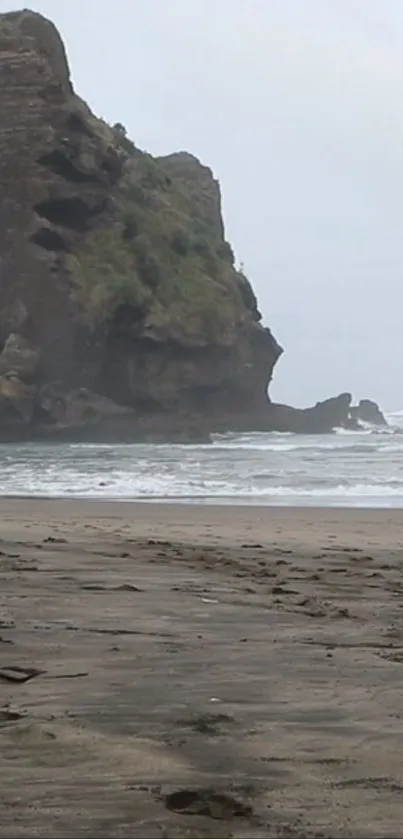 Serene beach with rock formations under a cloudy sky.