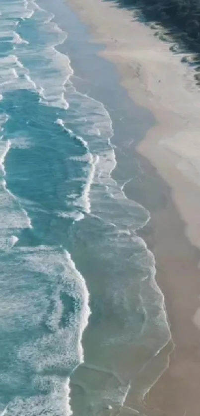 Aerial view of turquoise ocean waves and sandy beach coastline.