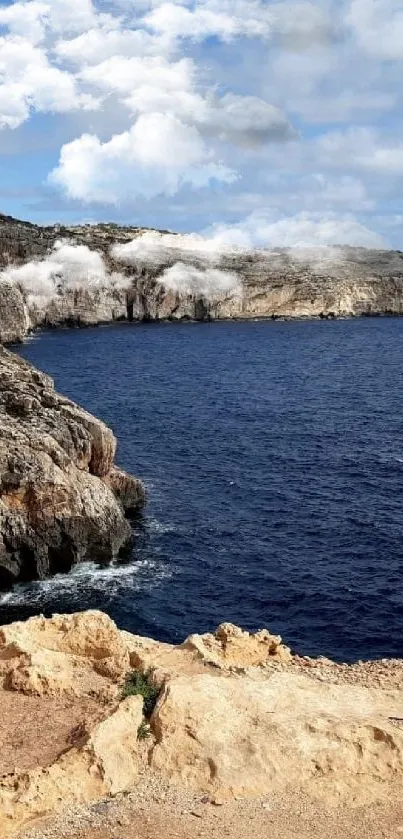 Serene coastal view with blue ocean and rocky cliffs under a cloudy sky.