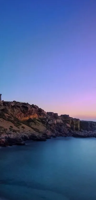 Serene lighthouse overlooking a coastal sunset scene with blue and purple skies.