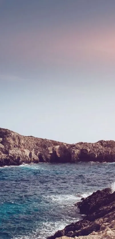 Serene coastal view with ocean and cliffs during sunset.