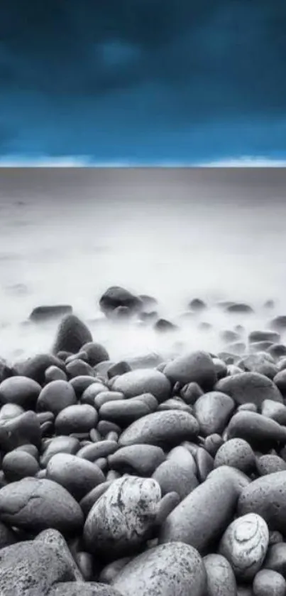 Serene coastal view with pebbles and blue sky wallpaper.